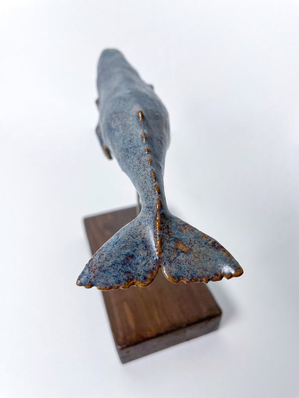 Sperm whale made of ceramics, on a wooden stand