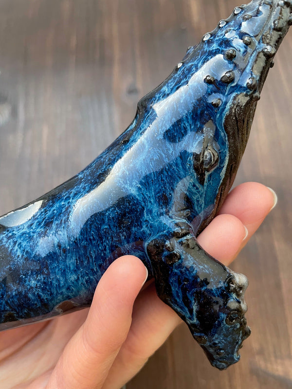 Humpback whale made of ceramics, on a wooden stand, beautiful glaring blue color, glossy