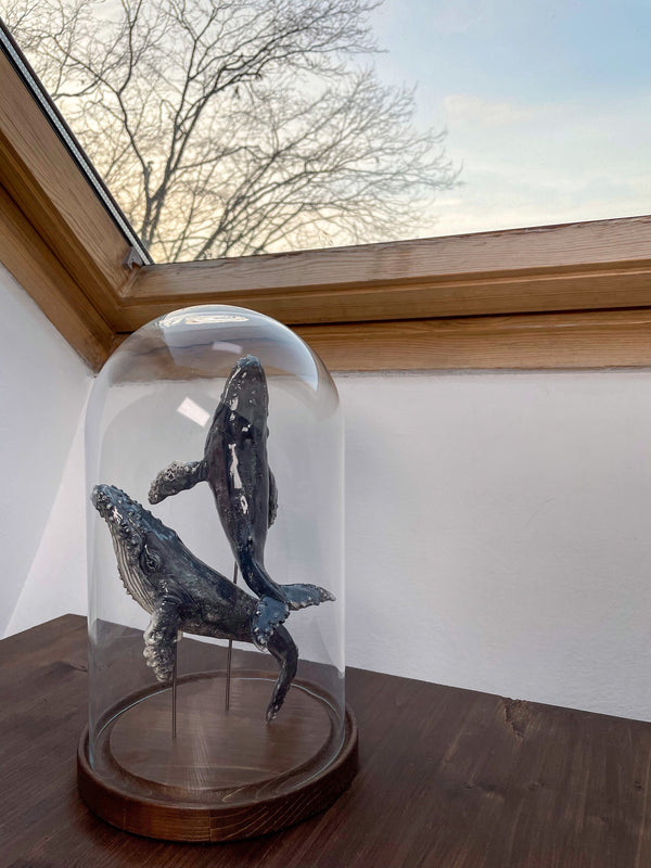 Humpback whales couple on a wooden stand under glass cloche, made of ceramics