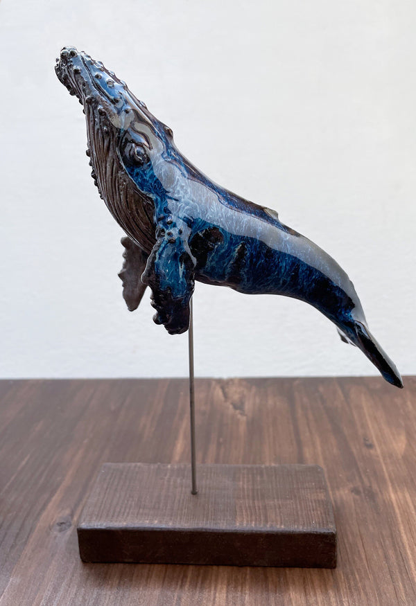 Humpback whale made of ceramics, on a wooden stand, beautiful glaring blue color, glossy