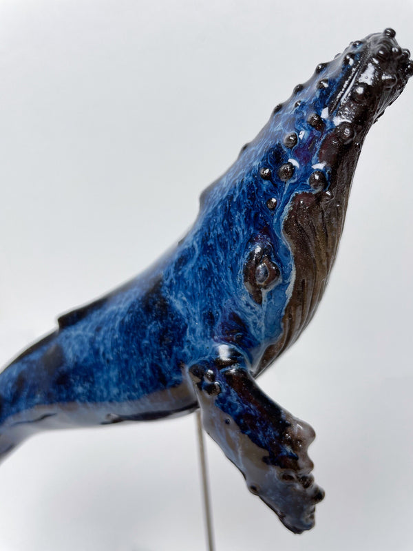 Humpback whale made of ceramics, on a wooden stand, beautiful glaring blue color, glossy
