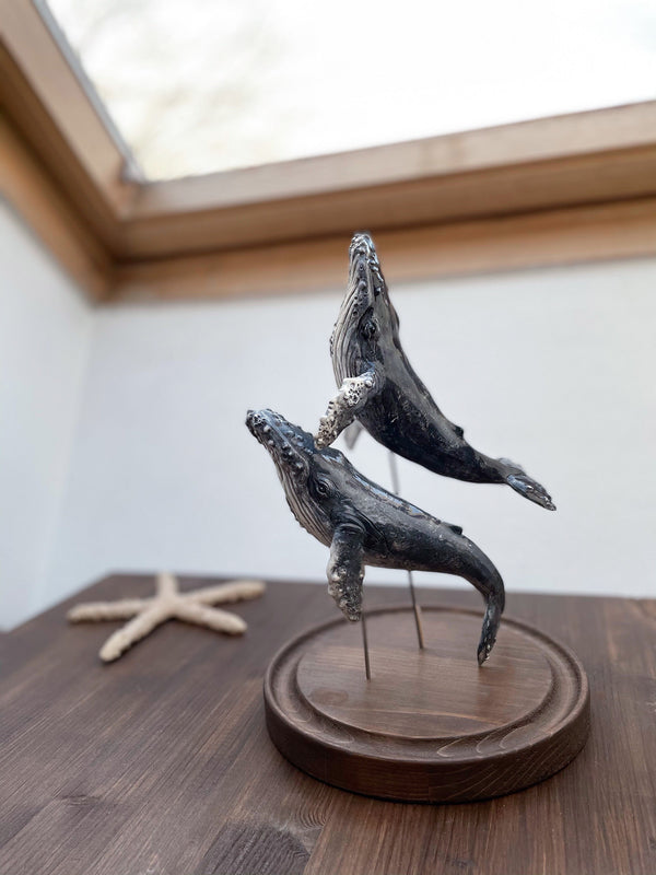 Humpback whales couple on a wooden stand under glass cloche, made of ceramics