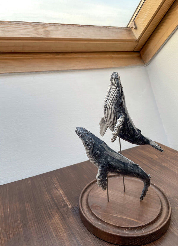 Humpback whales couple on a wooden stand under glass cloche, made of ceramics
