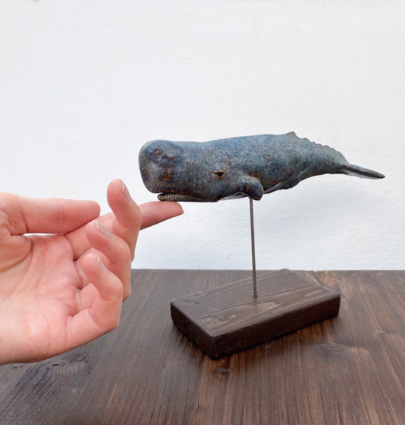 Sperm whale made of ceramics, on a wooden stand